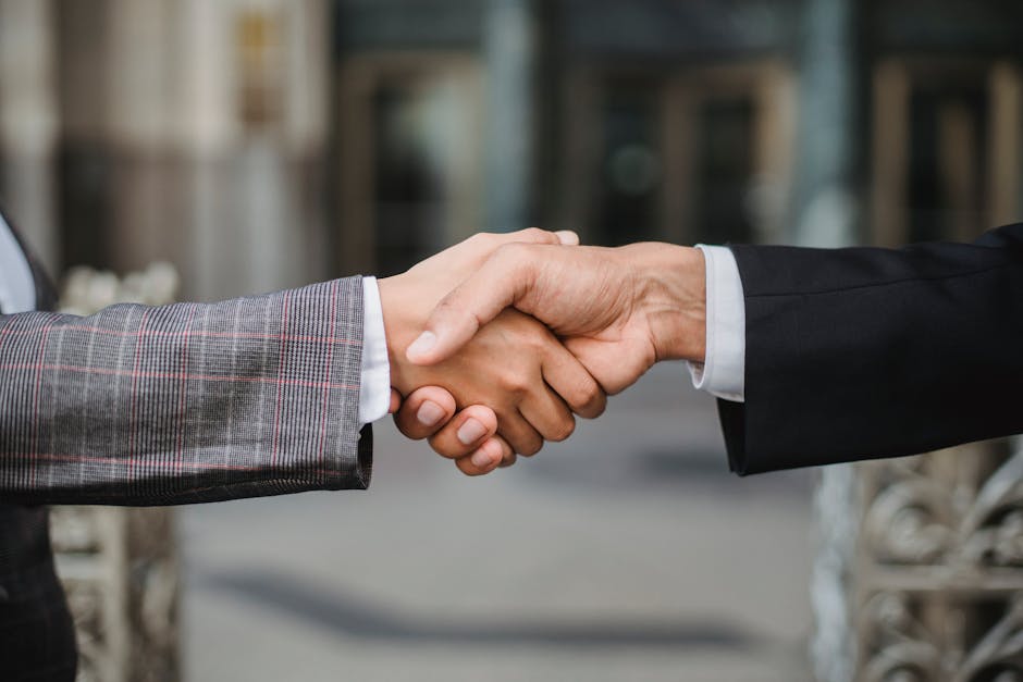 A close-up of two businesspeople shaking hands, symbolizing cooperation and partnership.